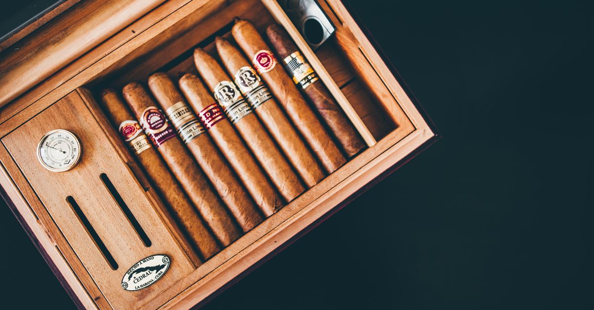 Close-up of premium Cuban cigars in a wooden humidor box, showcasing luxury and craftsmanship.